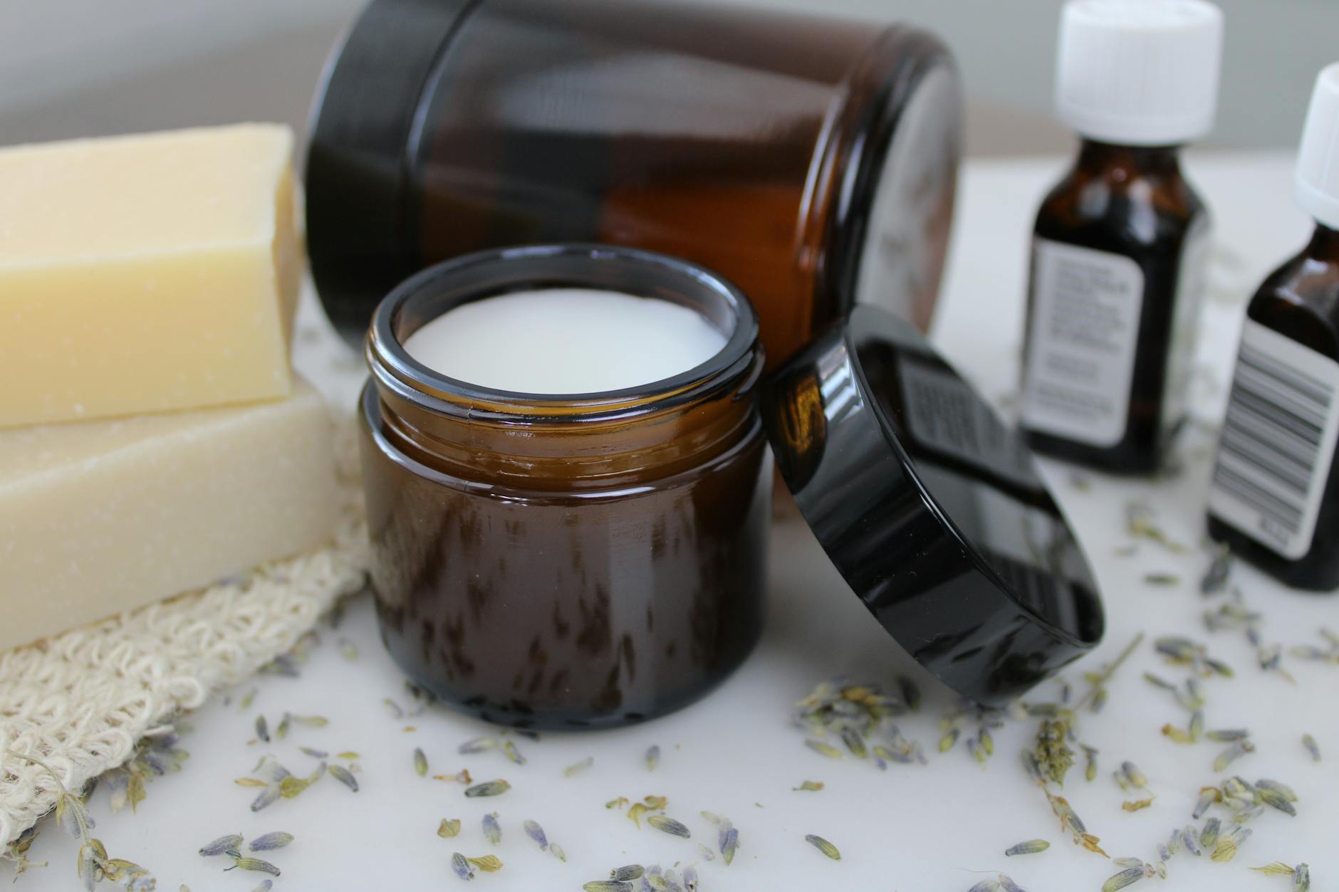 Szklane słoiczki z kosmetykami naturalnymi ustawione na blacie