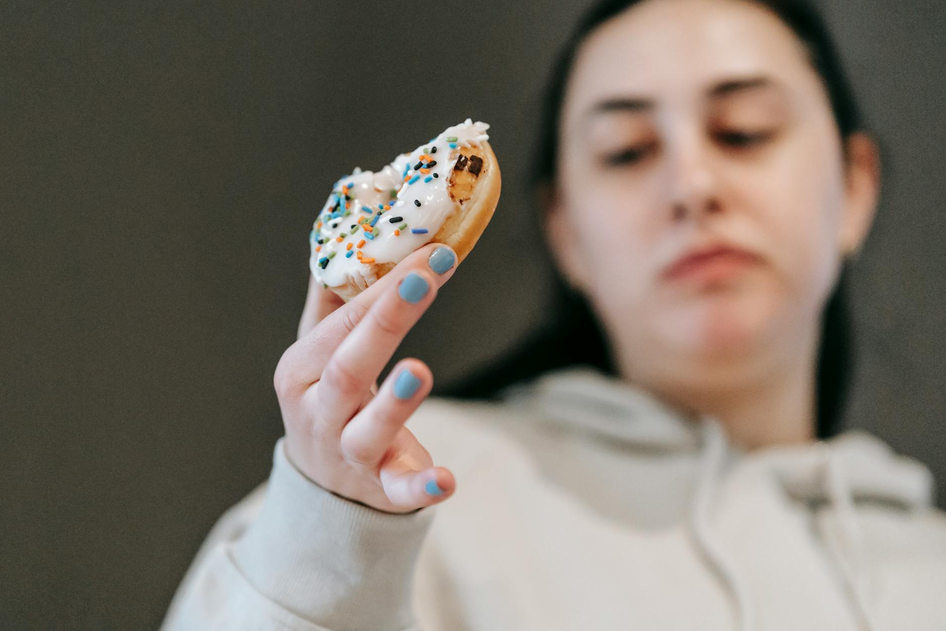 Kobieta bez emocji je pączka z lukrem waniliowym w jasnym pokoju