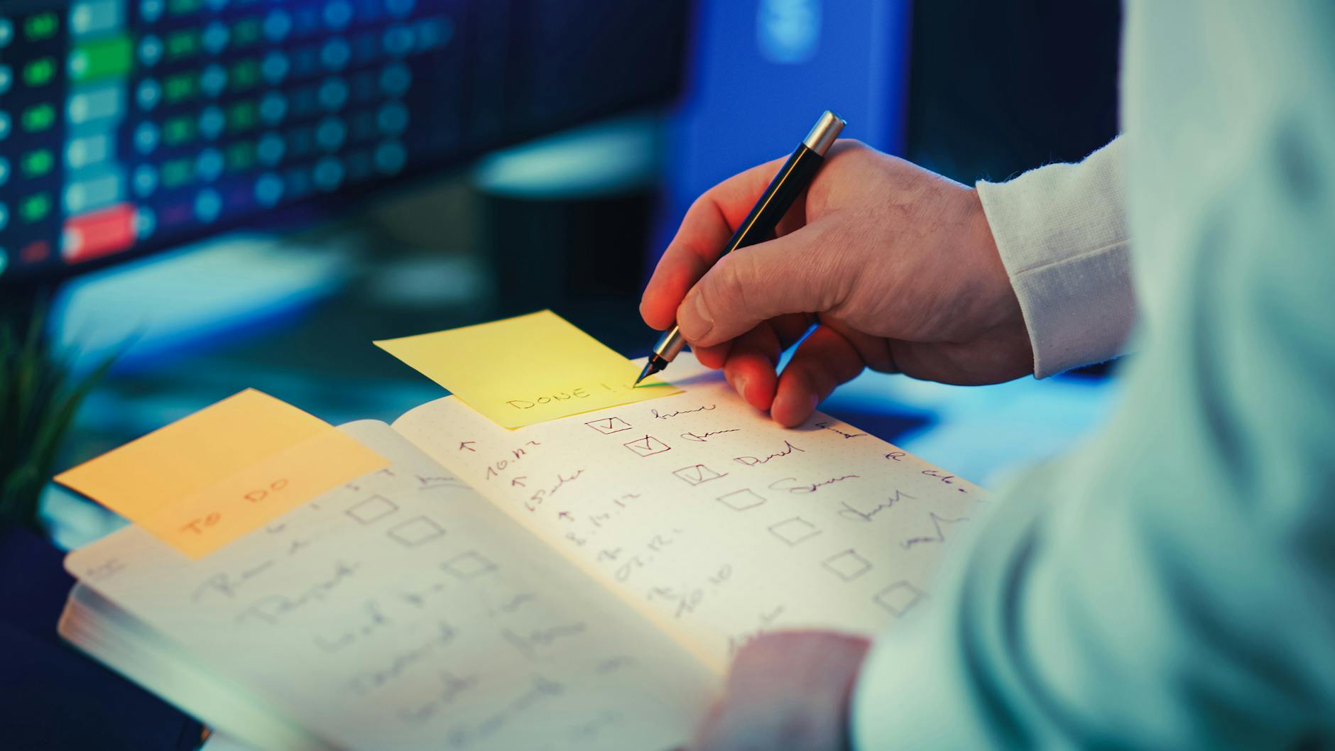 Osoba planująca dzień w papierowym planerze z listą zadań