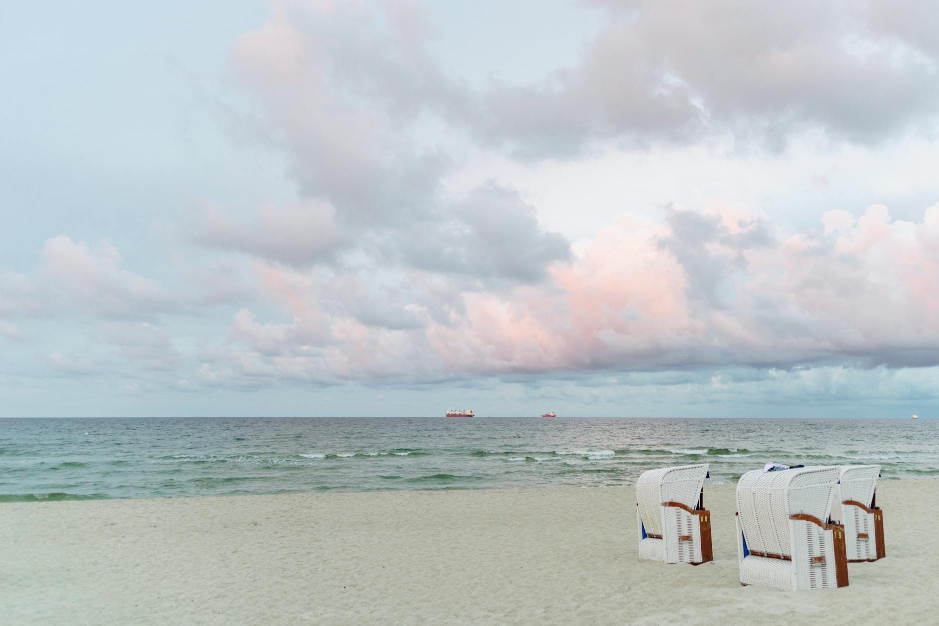 Spokojna plaża w Binz z koszami plażowymi i pastelowym niebem