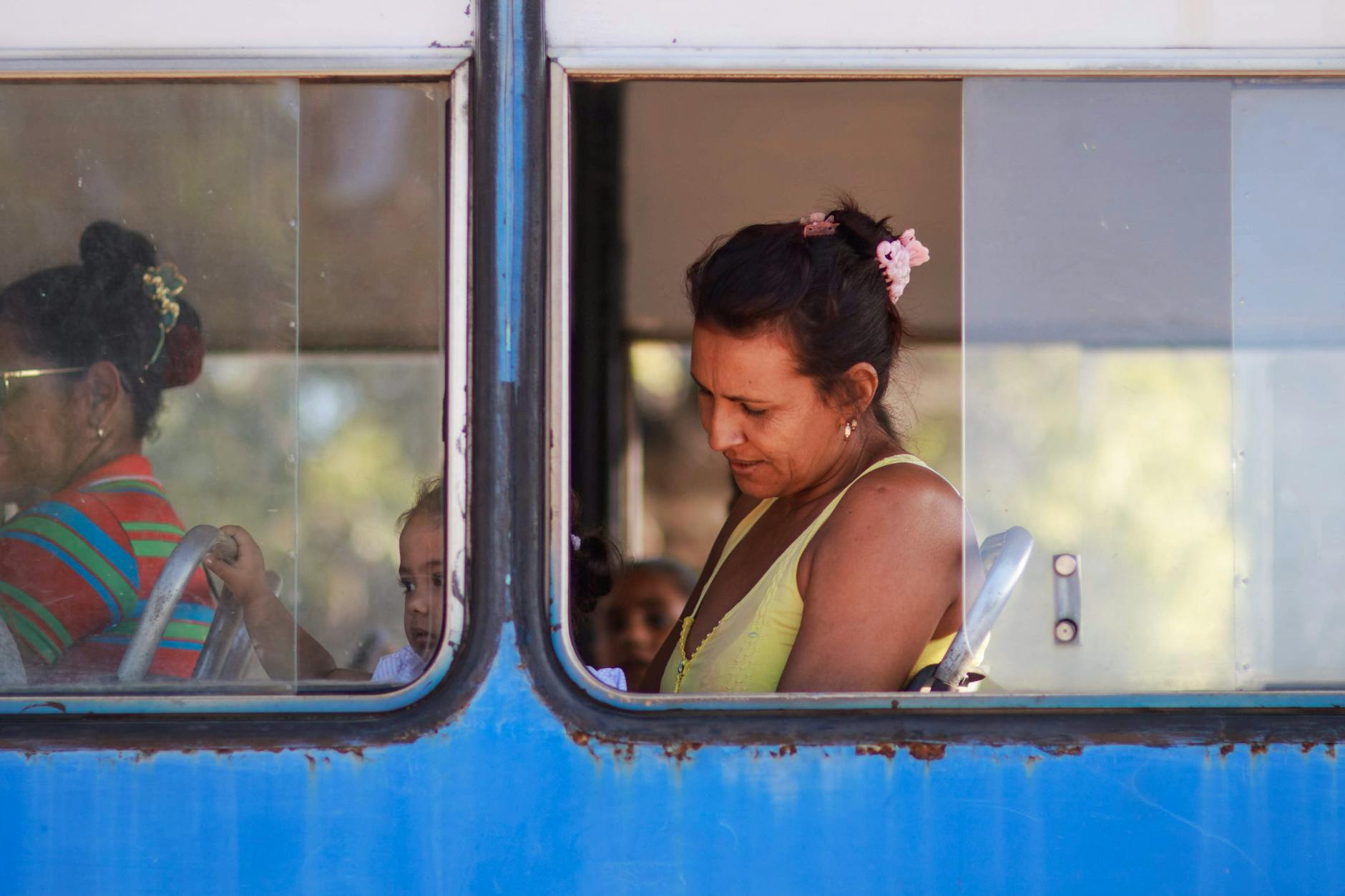 Kobieta siedząca w autobusie miejskim, widoczna przez szybę