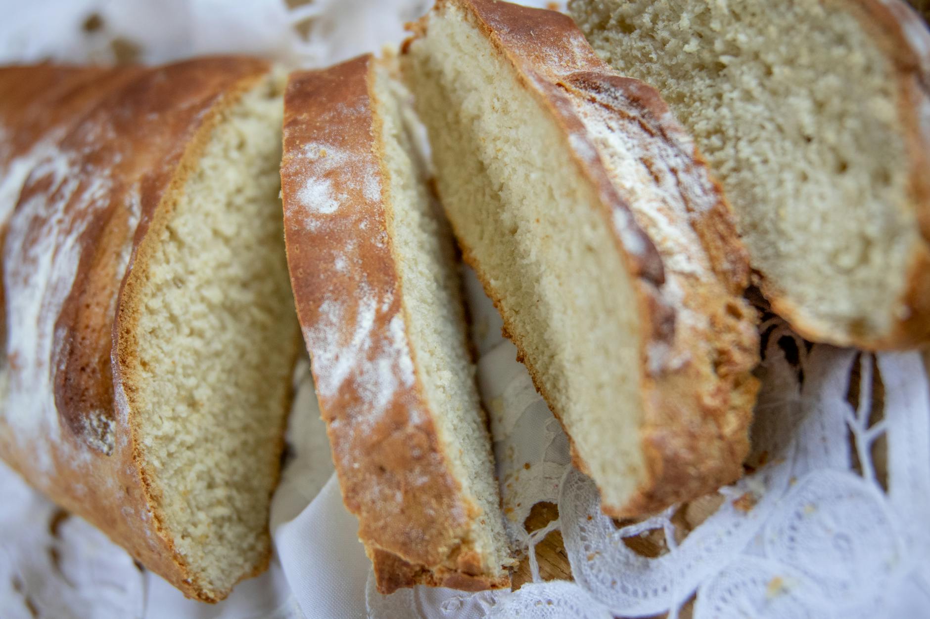 Kromki świeżo upieczonego chleba na koronkowej ściereczce