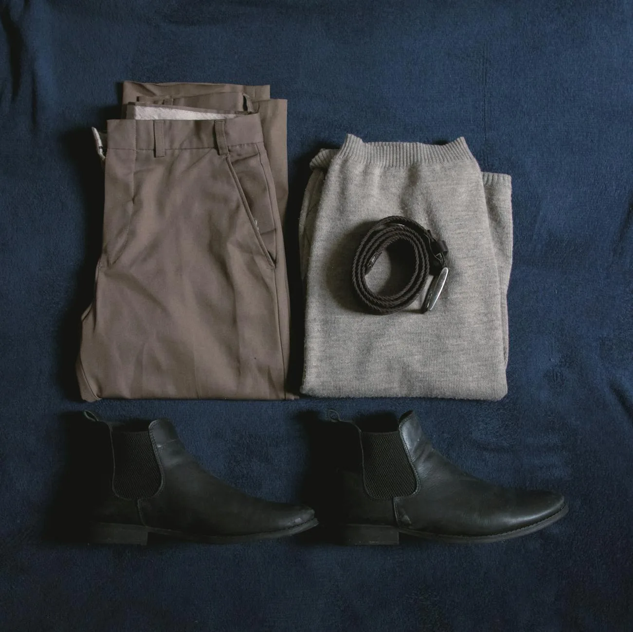 Męski zestaw basic: spodnie, sweter, pasek i buty na niebieskim tle