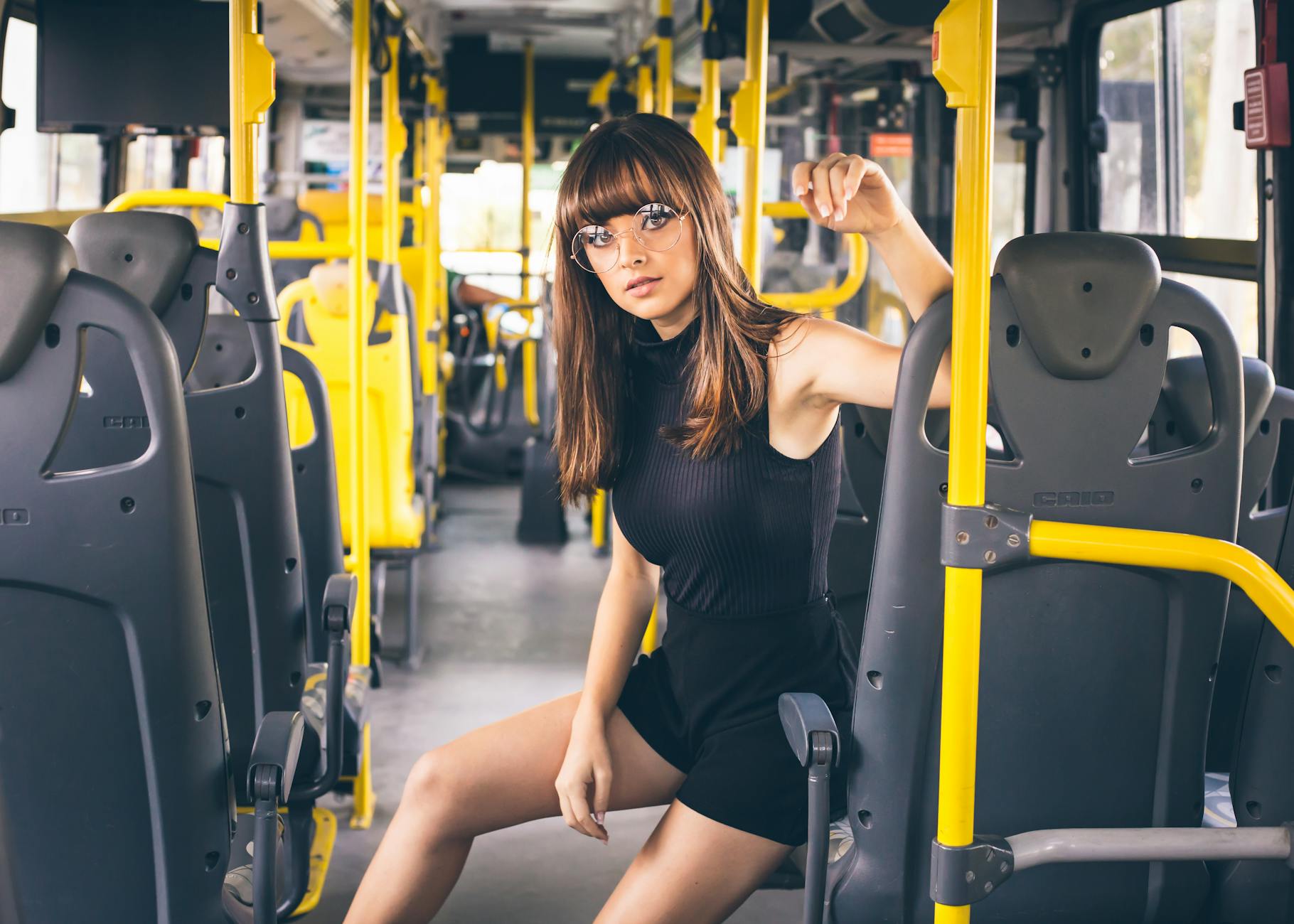 Młoda kobieta w okularach siedzi w nowoczesnym autobusie