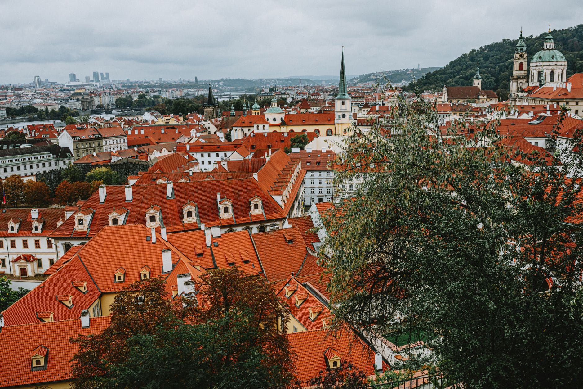 Czerwone dachy i zabytkowe kamienice w historycznym centrum Pragi