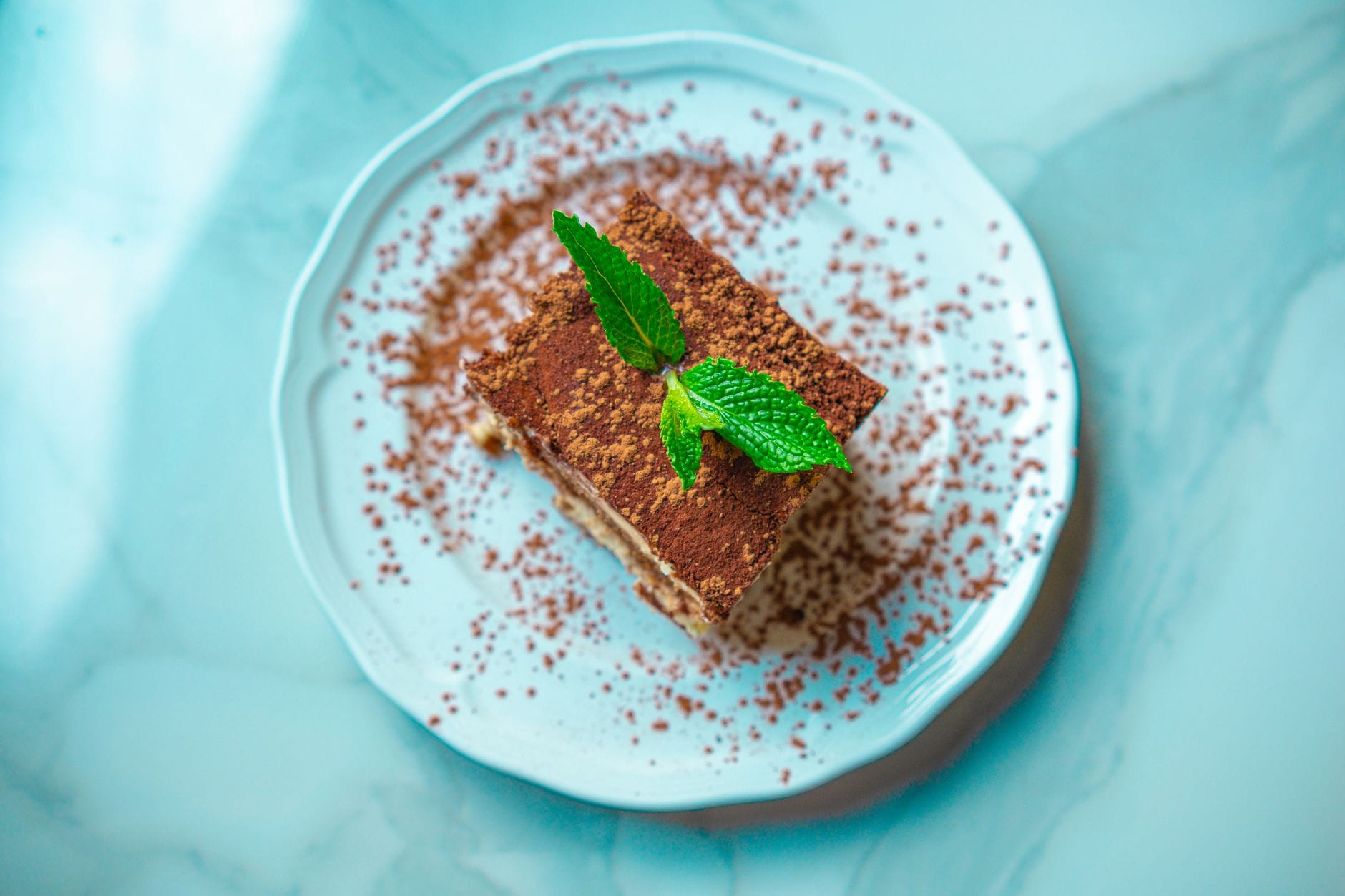 Porcja tiramisu z miętą na marmurowym talerzu