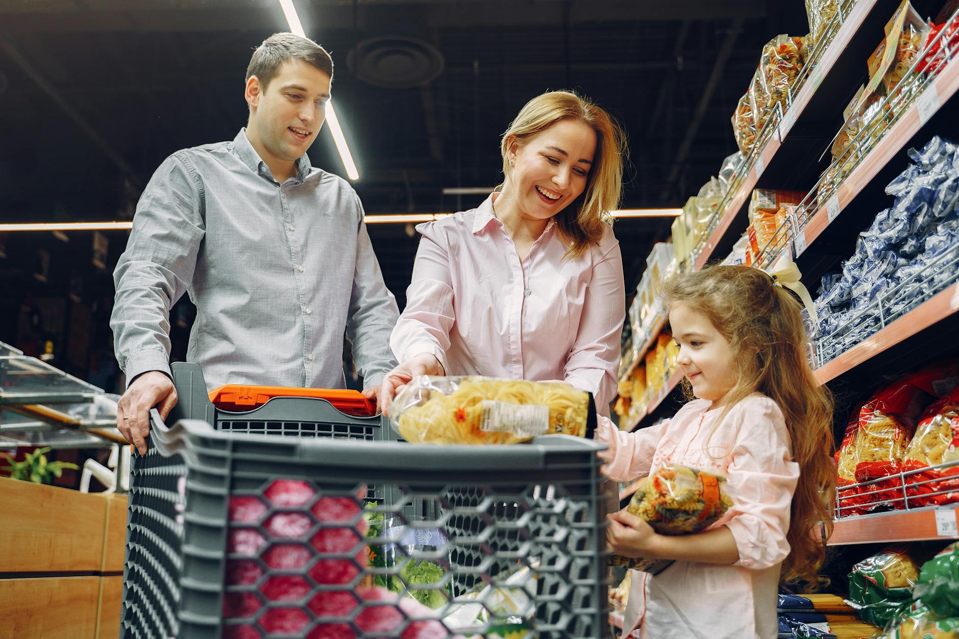 Rodzina z dzieckiem robi cotygodniowe zakupy spożywcze w supermarkecie