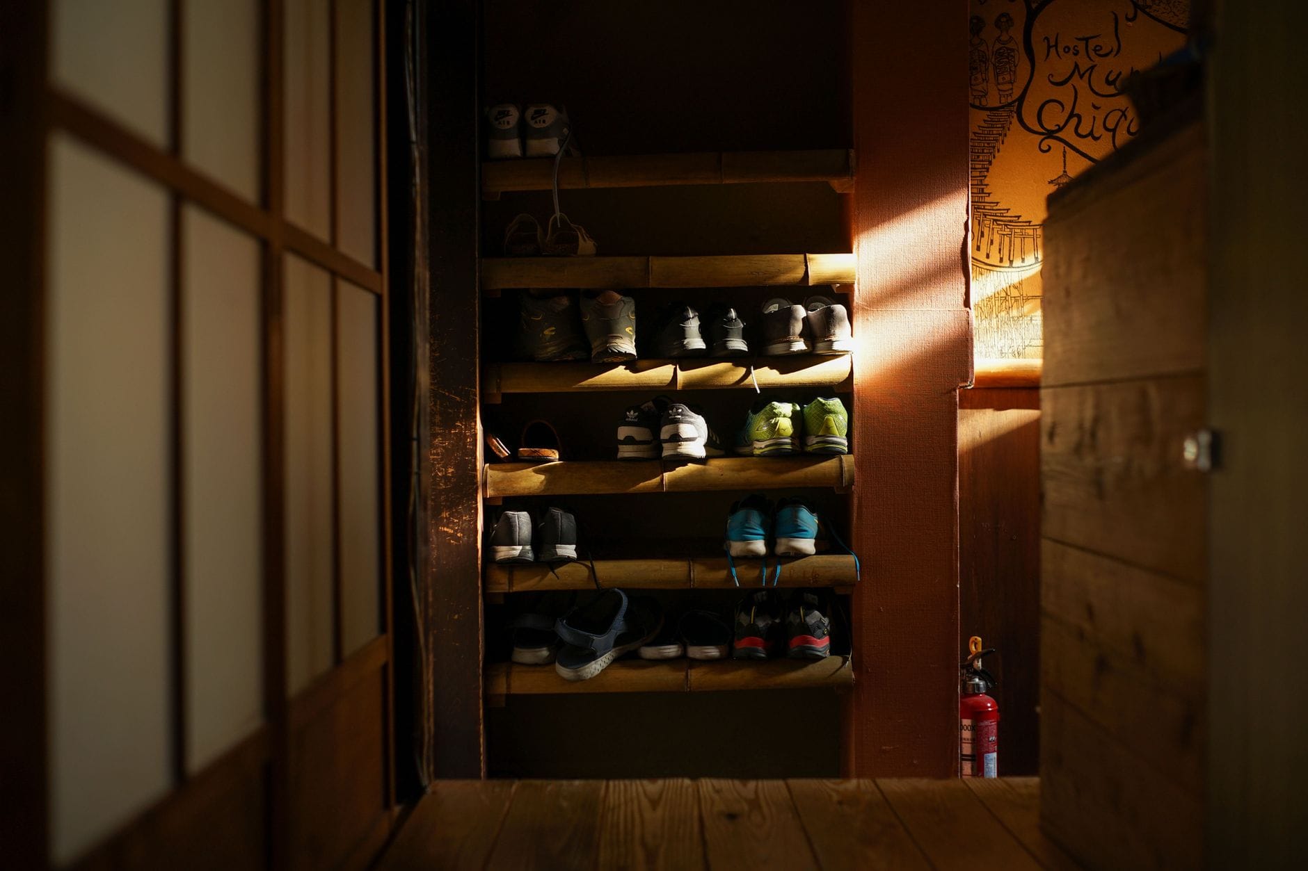 Drewniany stojak na buty z uporządkowanymi sneakersami w przedpokoju