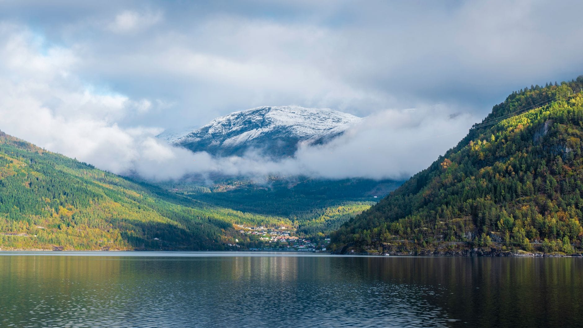 Norweski fiord otoczony górami pod zachmurzonym niebem Norweski fiord otoczony górami pod zachmurzonym niebem