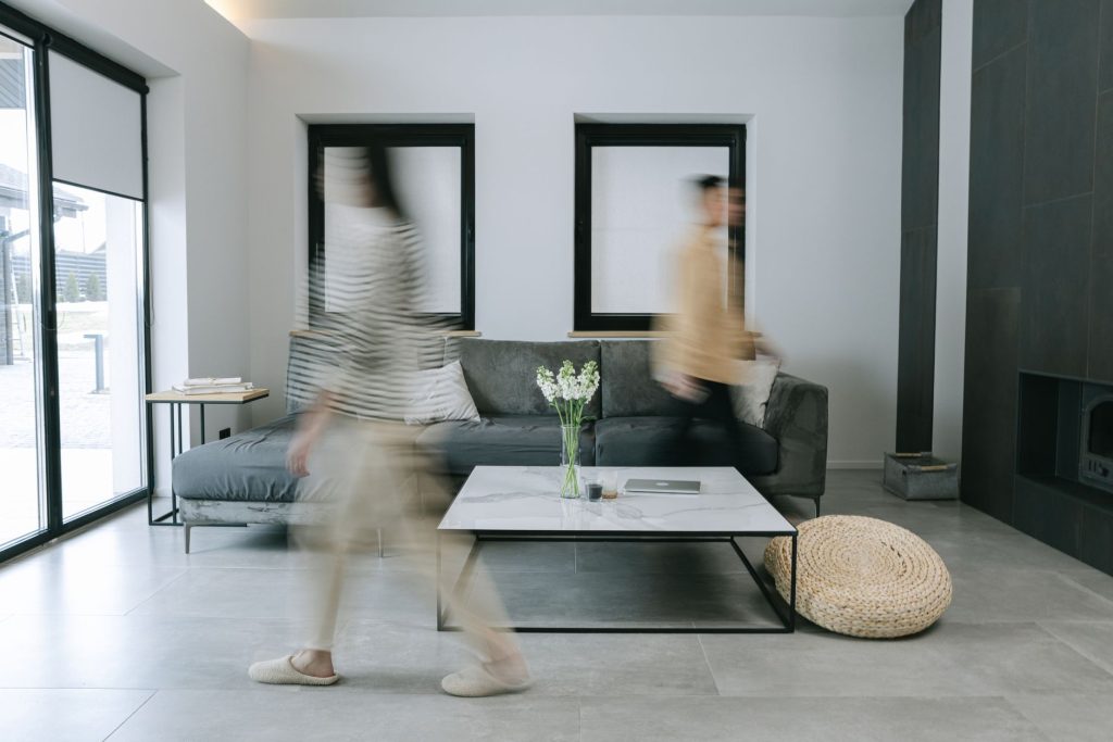 Minimalistyczny salon z osobami w ruchu